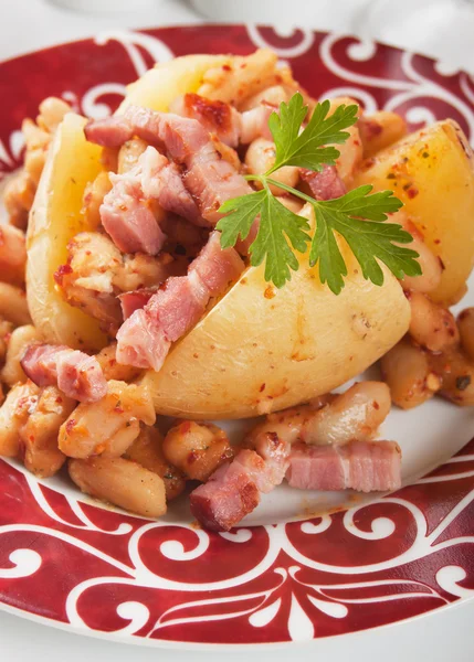 Pečená brambora ve slupce s bílými fazolemi a slaninou — Stock fotografie
