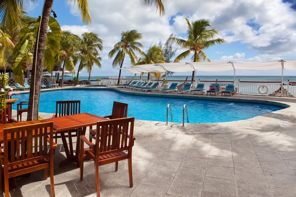 Tabulky u bazénu s výhledem na moře. Mauricius. — Stock fotografie