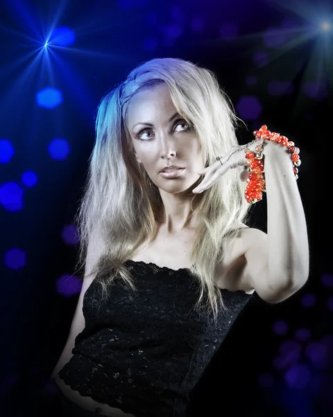 Vacker ung kvinna med långa blonda hår och ett rött armband på en mörk bakgrund — Stockfoto