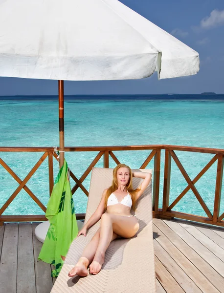 Giovane donna abbronzata su una terrazza di acqua villa sull'oceano Maldive — Foto Stock