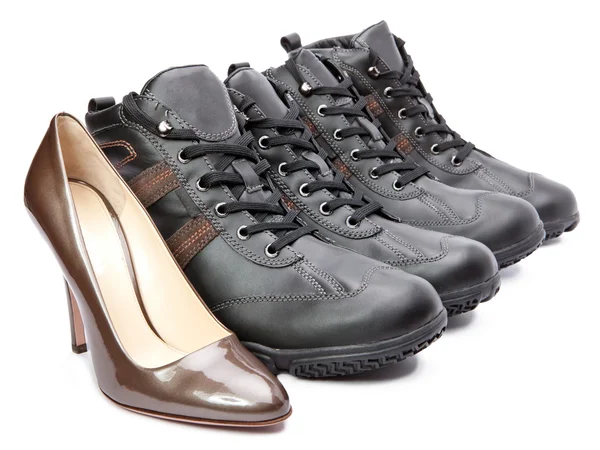 Pánské boty a elegantní ženské boty na bílém pozadí — Stock fotografie