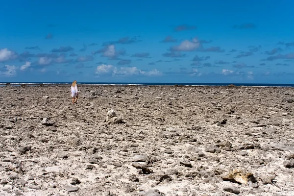 Flickan går på kusten från döda koraller — Stockfoto