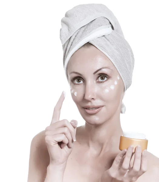 A bela jovem mulher em toalha com um creme cosmético — Fotografia de Stock