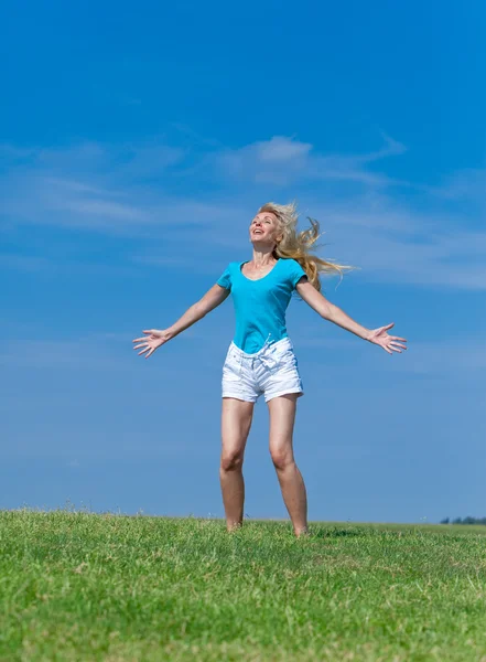 The happy young woman jumps in the field — Stock Photo, Image