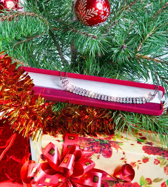 Presentask med ett halsband på ett nyårsträd — Stockfoto