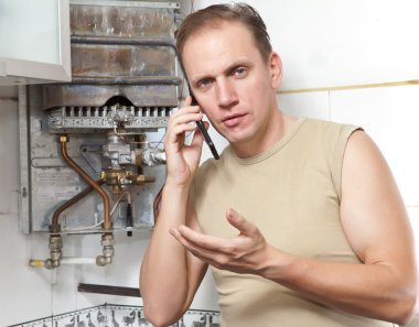 The man calls by phone to cause the repairman of gas water heaters clipart