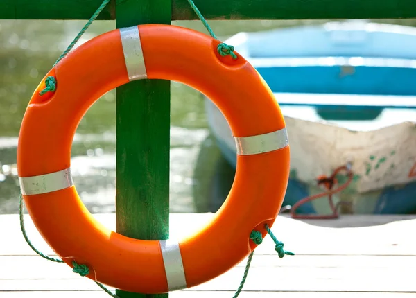 Lifebuoy біля причалу і човна на фоні — стокове фото