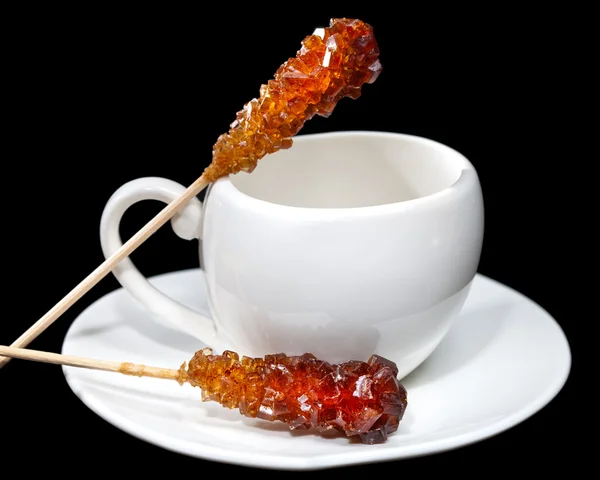 Coffee cup and candy sugar on a stick — Stock Photo, Image