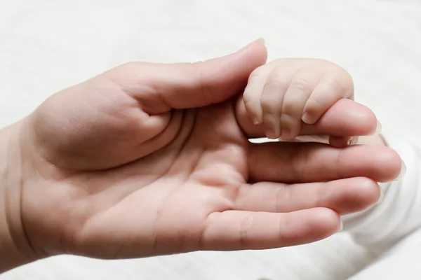 Baby die moeder hand — Stockfoto