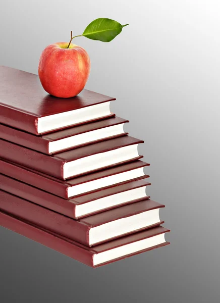 Red apple on pile of books on background — Stock Photo, Image