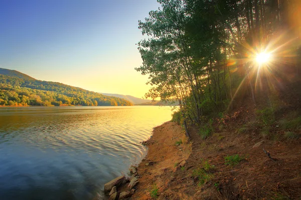 Pôr do sol ensolarado sobre o lago — Fotografia de Stock