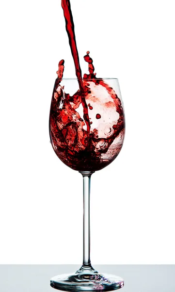 Red wine being poured into a crystal wine glass — Stock Photo, Image