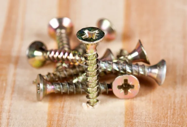 Screws on a wooden table — Stock Photo, Image