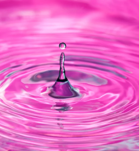 Kropla wody w powierzchnię różowy — Zdjęcie stockowe