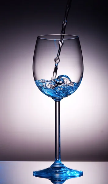 Petite quantité de liquide transparent dans le verre à vin — Photo