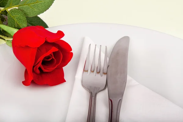 Closeup of rose, plate and silver cutlery — Stock Photo, Image