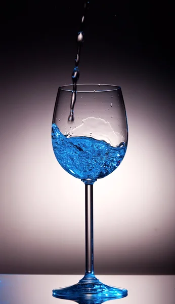 Clear liquid poured into crystal wine glass — Stock Photo, Image