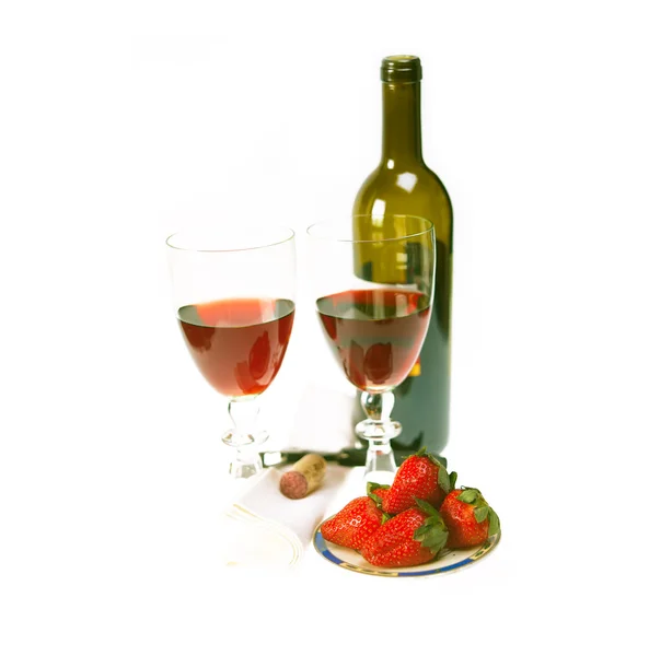 Láhev červeného vína a dvě sklenice s jahodami — Stock fotografie