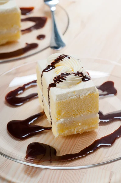 stock image Fresh cream cake closeup with chocolate sauce