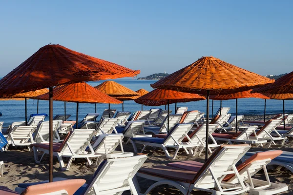 Stranden solstolar och parasoller på havet. — Stockfoto