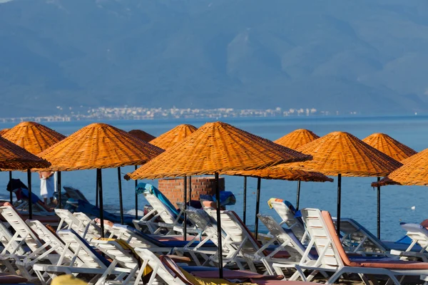 Plaj şezlongları ve şemsiyeler denizde. — Stok fotoğraf