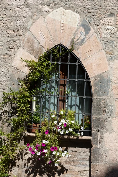 Цветы висят на окне дома — стоковое фото