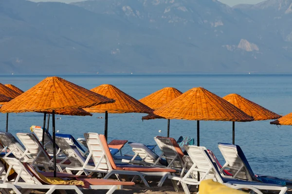 Stranden solstolar och parasoller på havet. — Stockfoto
