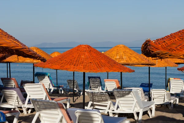 Liegestühle und Sonnenschirme am Meer. — Stockfoto