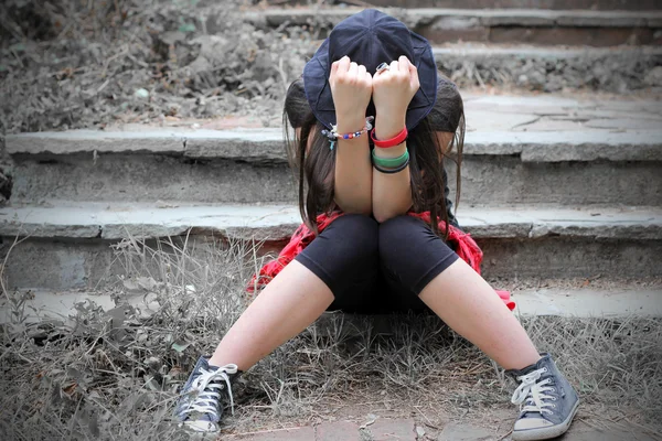 Дівчина-підліток зі прихованим обличчям в її руках — стокове фото