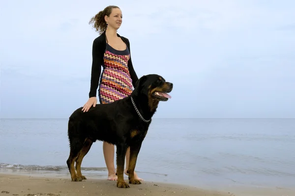 Rottweiler and woman on the beach — Stock Photo, Image