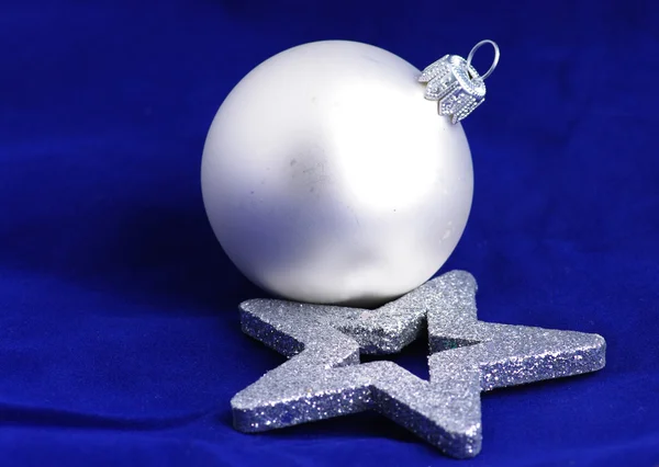 A silver christmas ball and silver christmas star on a blue back — Stock Photo, Image