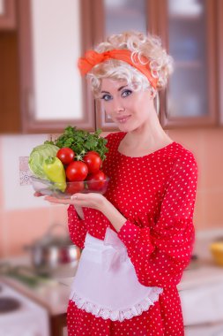 Woman with vegetables in kitchen clipart