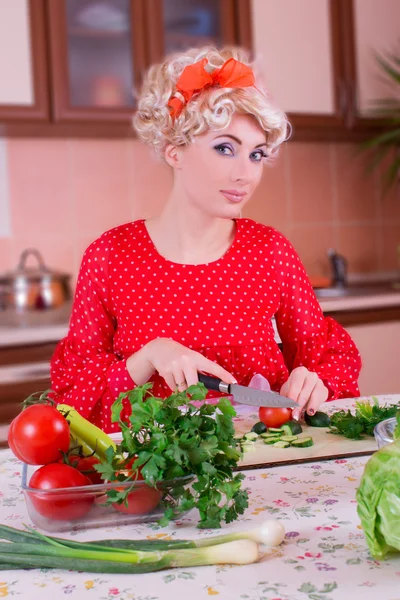 Woman in red cutting vegetables — Stock Photo, Image