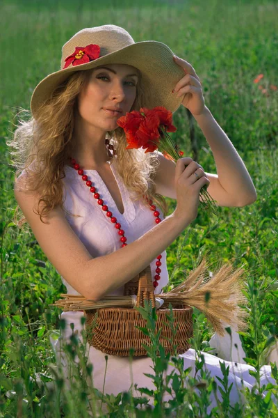 Женщина в шляпе с маковым букетом — стоковое фото
