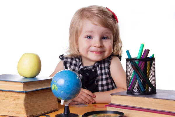 Дівчина сидить за столом з книгами і глобусом — стокове фото