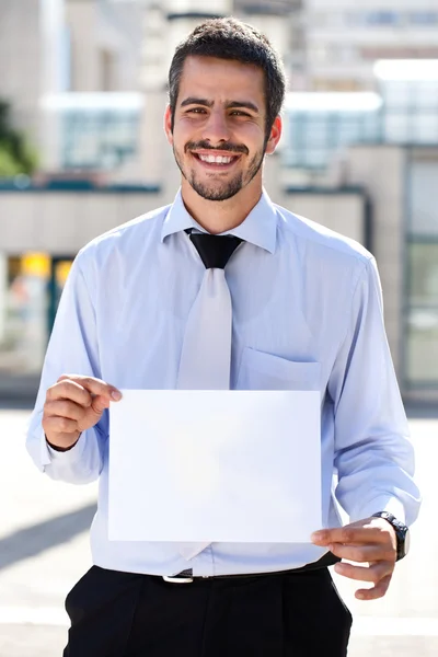 Бізнесмен тримає чистий папір — стокове фото