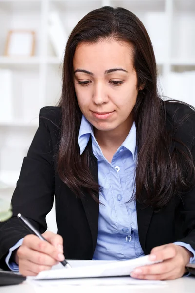 Jovem empresária escrevendo um contrato no escritório — Fotografia de Stock