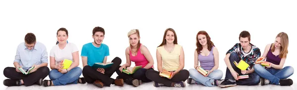 Группа студентов, сидящих на полу изолированы — стоковое фото