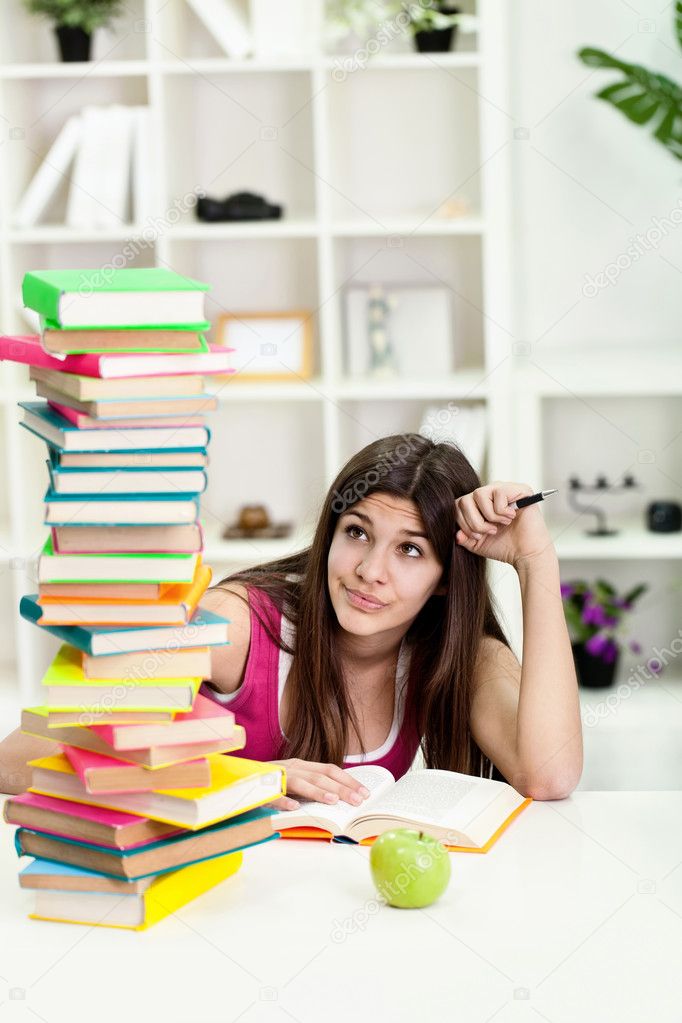 Unhappy student with big stack of books
