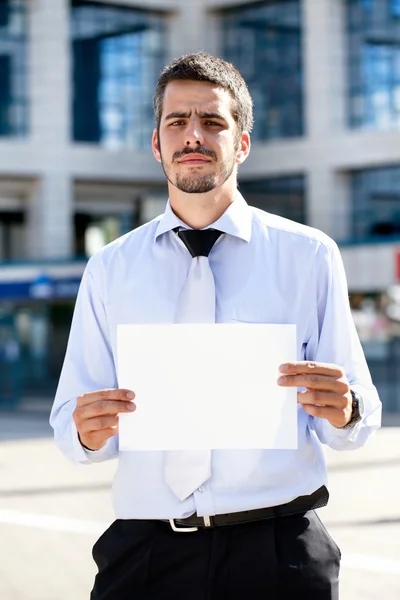 Businessman holding a blank sign outdoor — Stock Photo, Image