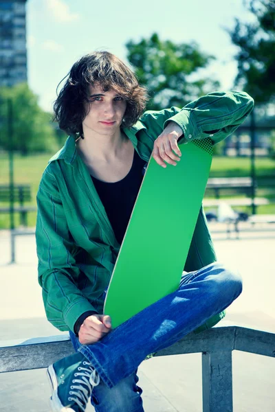 Skater poseren met zijn skateboard — Stockfoto