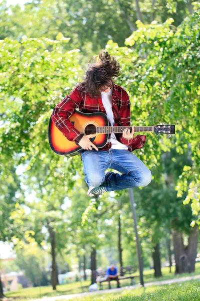 Boy jumping with guitar — Stock Photo, Image