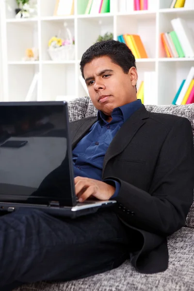 Młody człowiek korzystający z laptopa w domu — Zdjęcie stockowe
