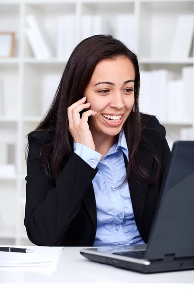 Lachende jonge zakenvrouw werken in office — Stockfoto