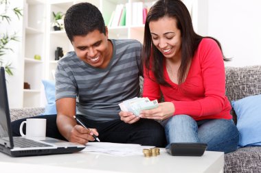 Smiling couple paying bills at home