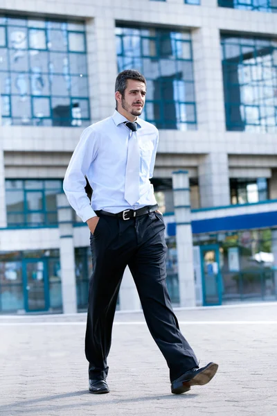 Mladý podnikatel chodí a drží aktovku — Stock fotografie