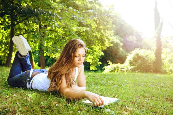 Junge Frau liest im Park — Stockfoto