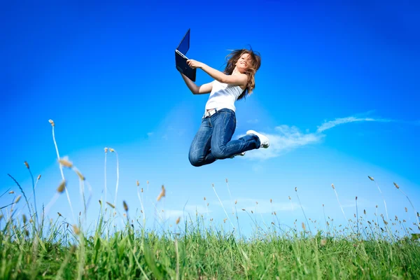 Jumping woman with laptop — Stock Photo, Image