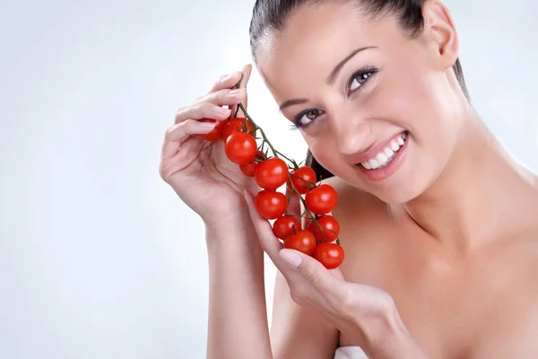 Vrouw met bos van cherry tomaten. — Stockfoto