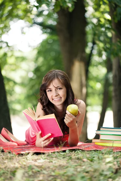 Menina com livro e maçãs — Fotografia de Stock